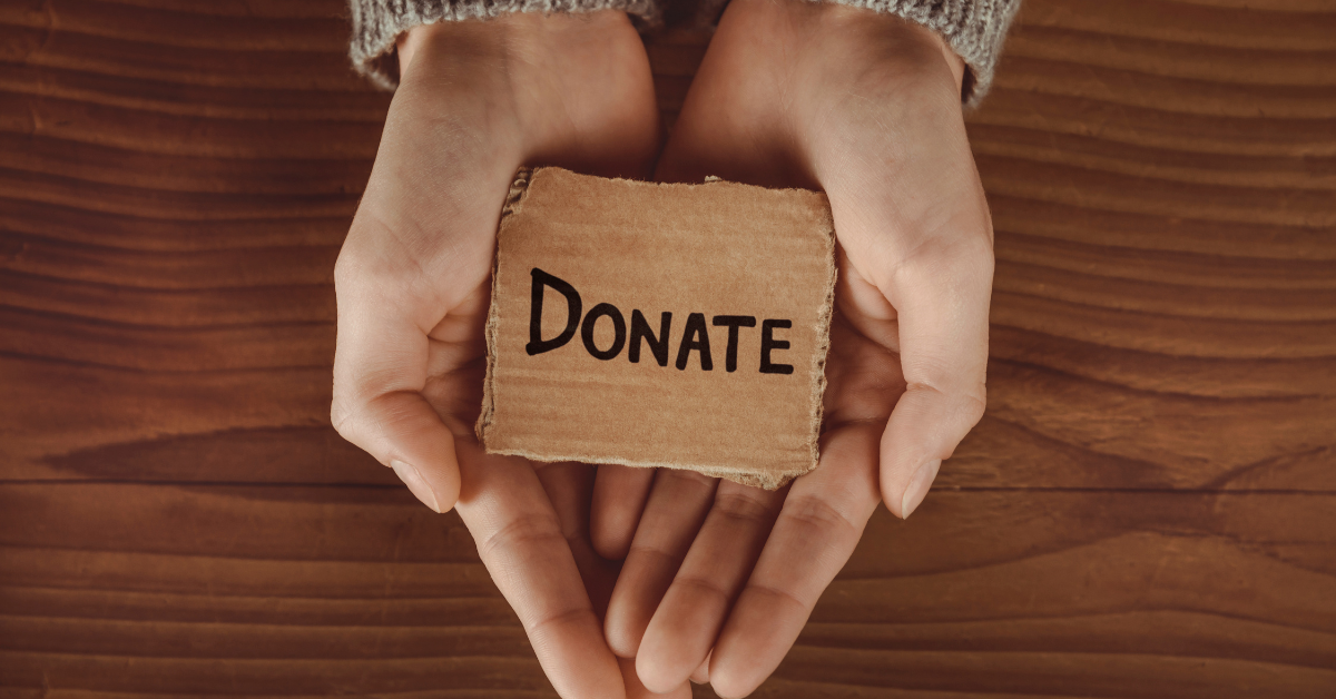 hands holding a donate sign